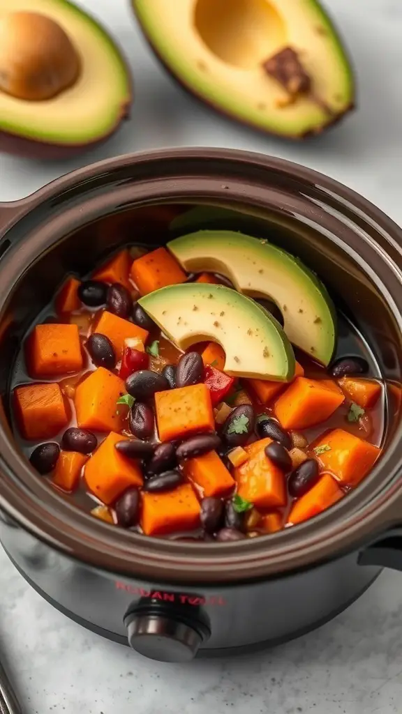 A mini crockpot filled with sweet potato and black bean stew, topped with avocado slices.