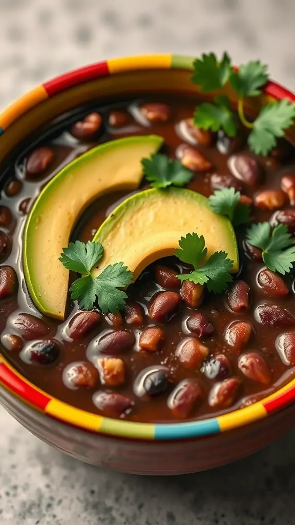A colorful bowl of black bean soup topped with avocado slices and cilantro.